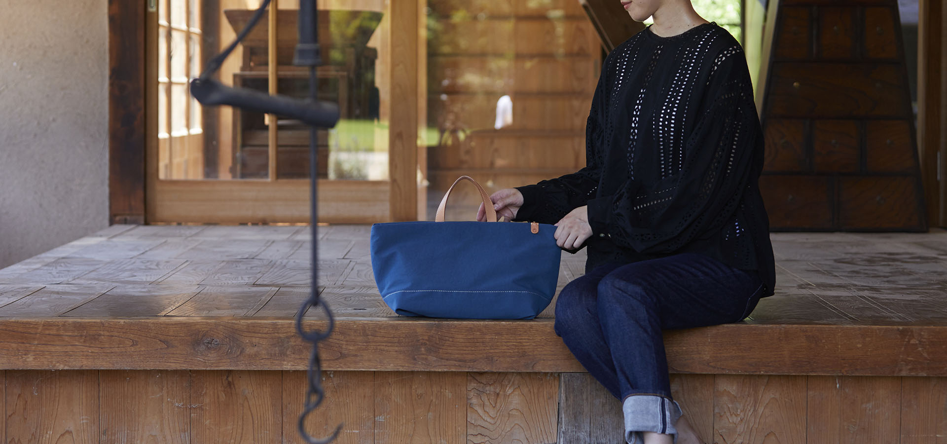 Atelier nuuのトートバッグを手にし座る女性　YURI CO.,LTD.